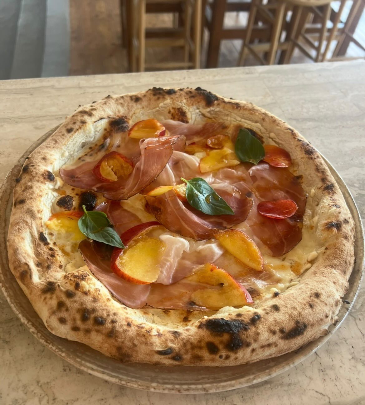 Neapolitan pizza with prosciutto, peaches, basil and ricotta